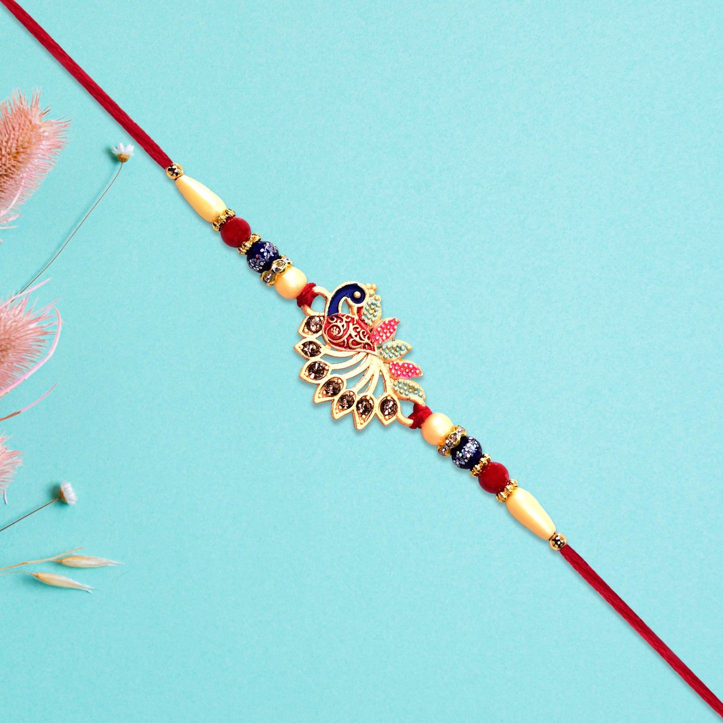 Colorful Peacock Rakhi With Stone Detailing And Red Thread